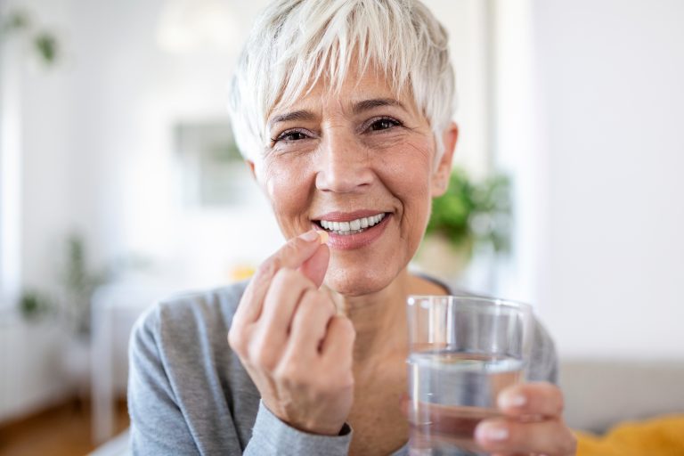 Ältere Frau nimmt Omega-3-Kapsel ein