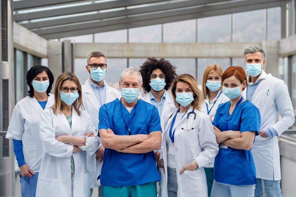 Gruppe von Ärztinnen und Ärzten mit Mundschutz spezialisiert auf chronische Krankheiten