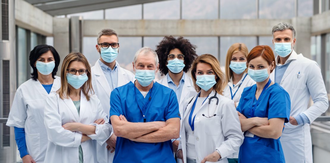 Gruppe von Ärztinnen und Ärzten mit Mundschutz spezialisiert auf chronische Krankheiten